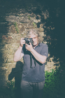 An image of a photographer holding a camera, the camera is a Mamiya 7ii.