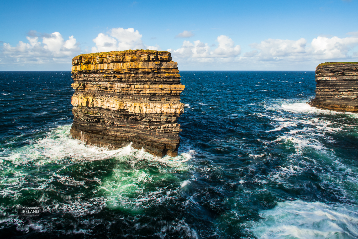 Dun Briste, County Mayo surrounded by crashing waves. Sea stack on Ireland's Atlantic coast, layers of sedimentary rocks and crashing waves.
