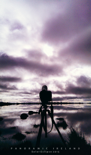 A camera sits on a tripod looking at a cloudy sky, not the solar eclipse