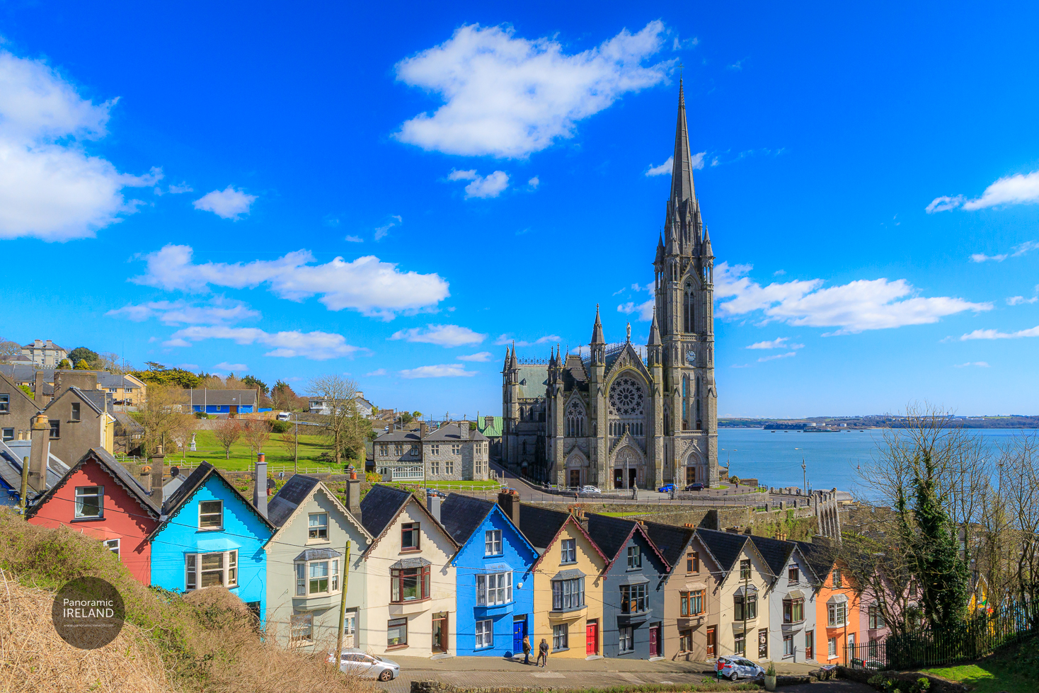 A row of brightly painted houses in Cobh, County Cork, Ireland known as the Deck of Cards sit underneath the imposing spire of Saint Colman's Cathedral. A row of brightly painted houses in Cobh, County Cork, Ireland known as the Deck of Cards sit underneath the imposing spire of Saint Colman's Cathedral.